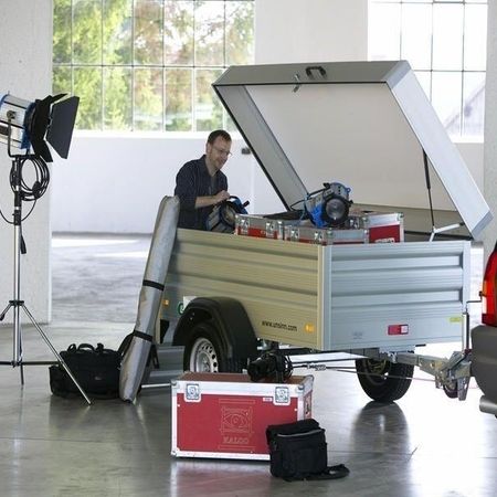 Aufnahme eines Technikers, der gerade sein Equipment aus einem Kastenanhänger hervorholt